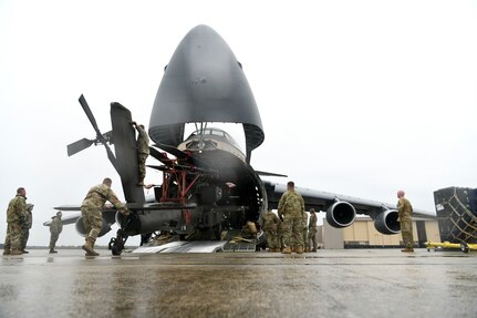 U.S. Airmen assigned to the 20th Logistics Readiness Squadron at Shaw Air Force Base, S.C., and the 337th Airlift Squadron from Westover Air Reserve Base, Mass., and U.S. Soldiers assigned to the 1-151st Attack Reconnaissance Battalion, South Carolina Army National Guard, load an AH-64E Apache Guardian helicopter onto a C-5M Super Galaxy at Shaw AFB, March 22, 2024. The two-day process marked the first time U.S. Army AH-64Es were loaded into a C-5M at Shaw AFB.