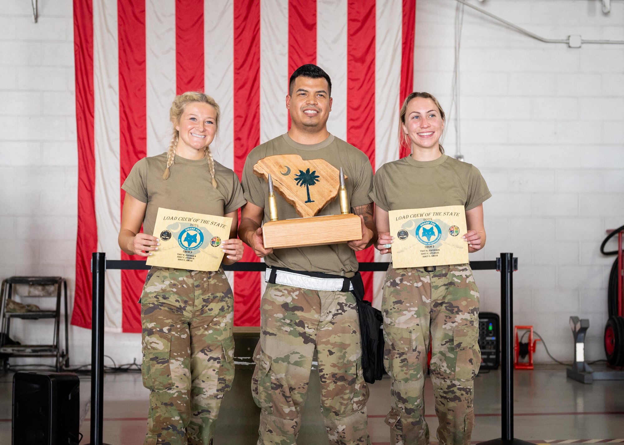 The 169th Aircraft Maintenance Squadron weapons load crew poses for a photo with their trophy.