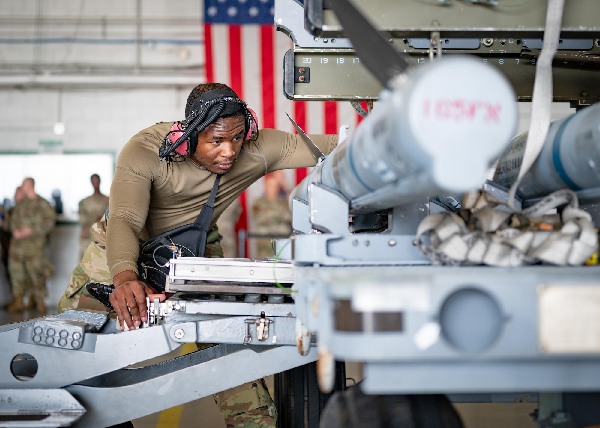 An Airman supervises the lifting of a munition.