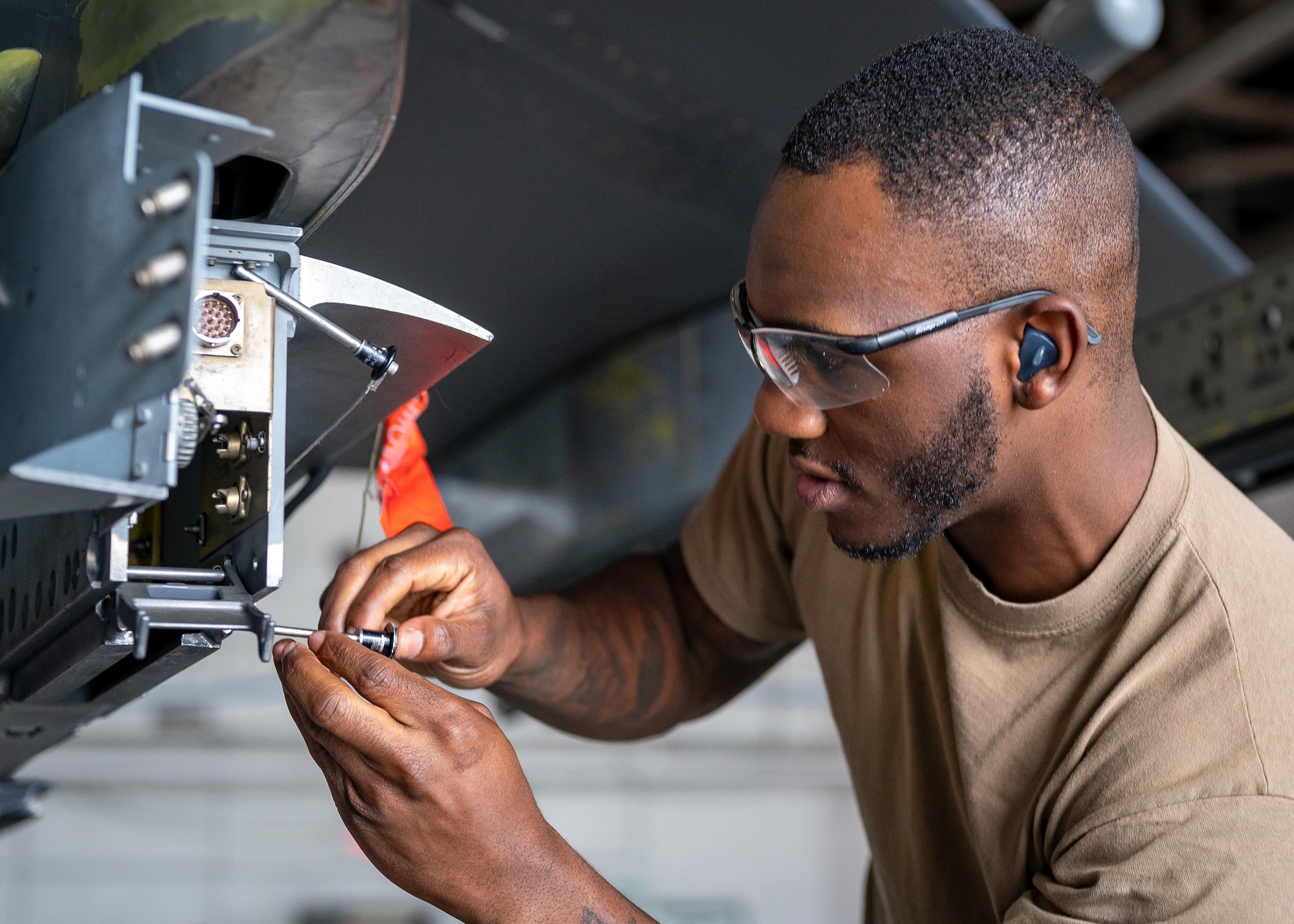 An Airman tightens screws on a munition.