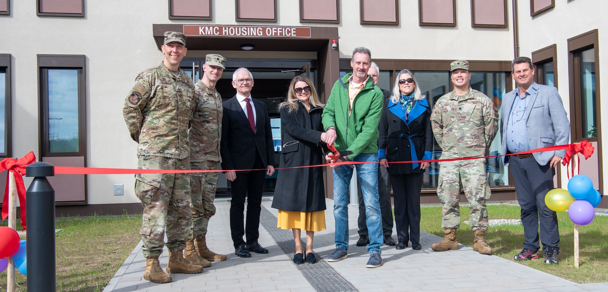 People stand and cut ribbon at ceremony