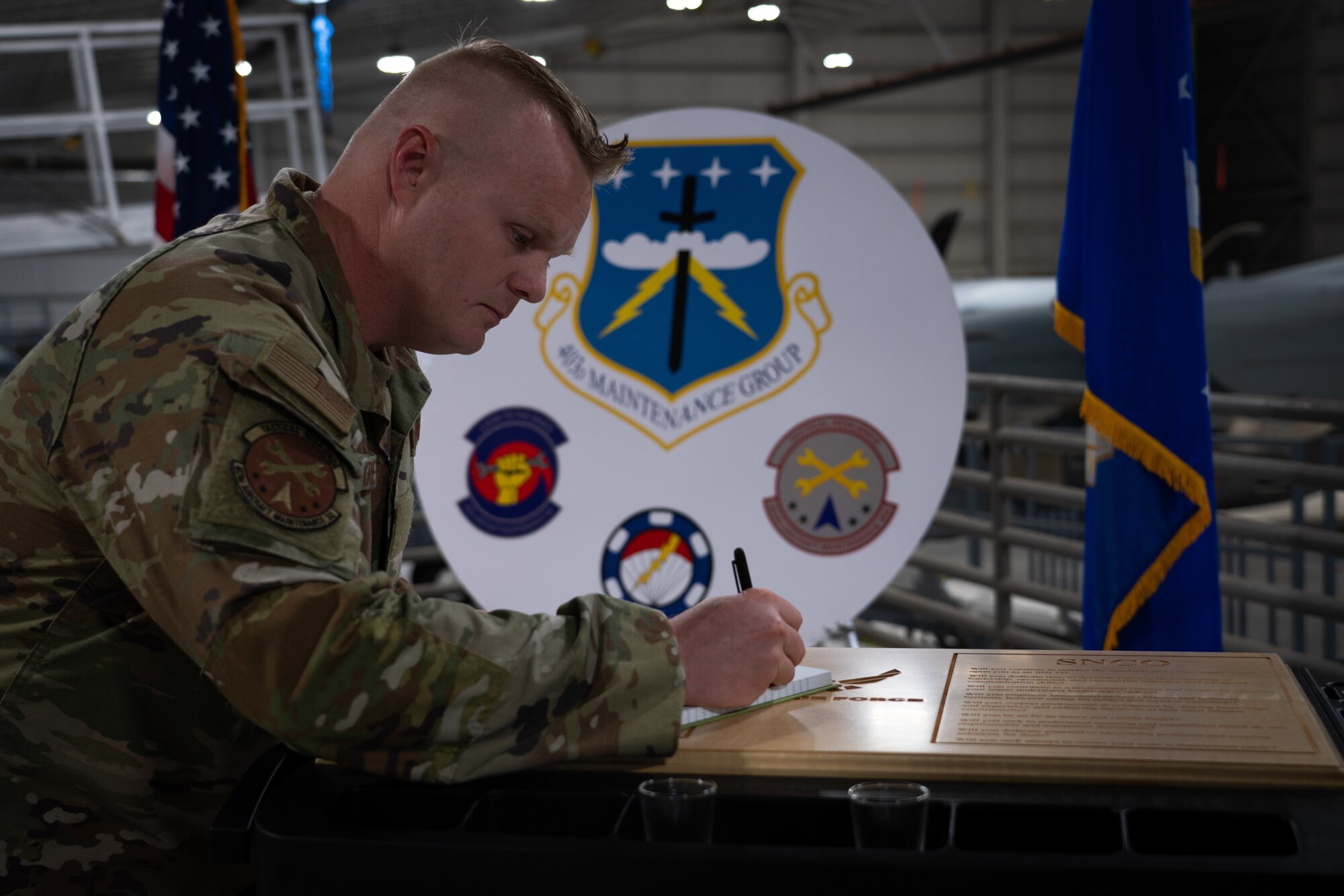 New staff sergeant signs the NCO book after being sworn into the NCO ranks.