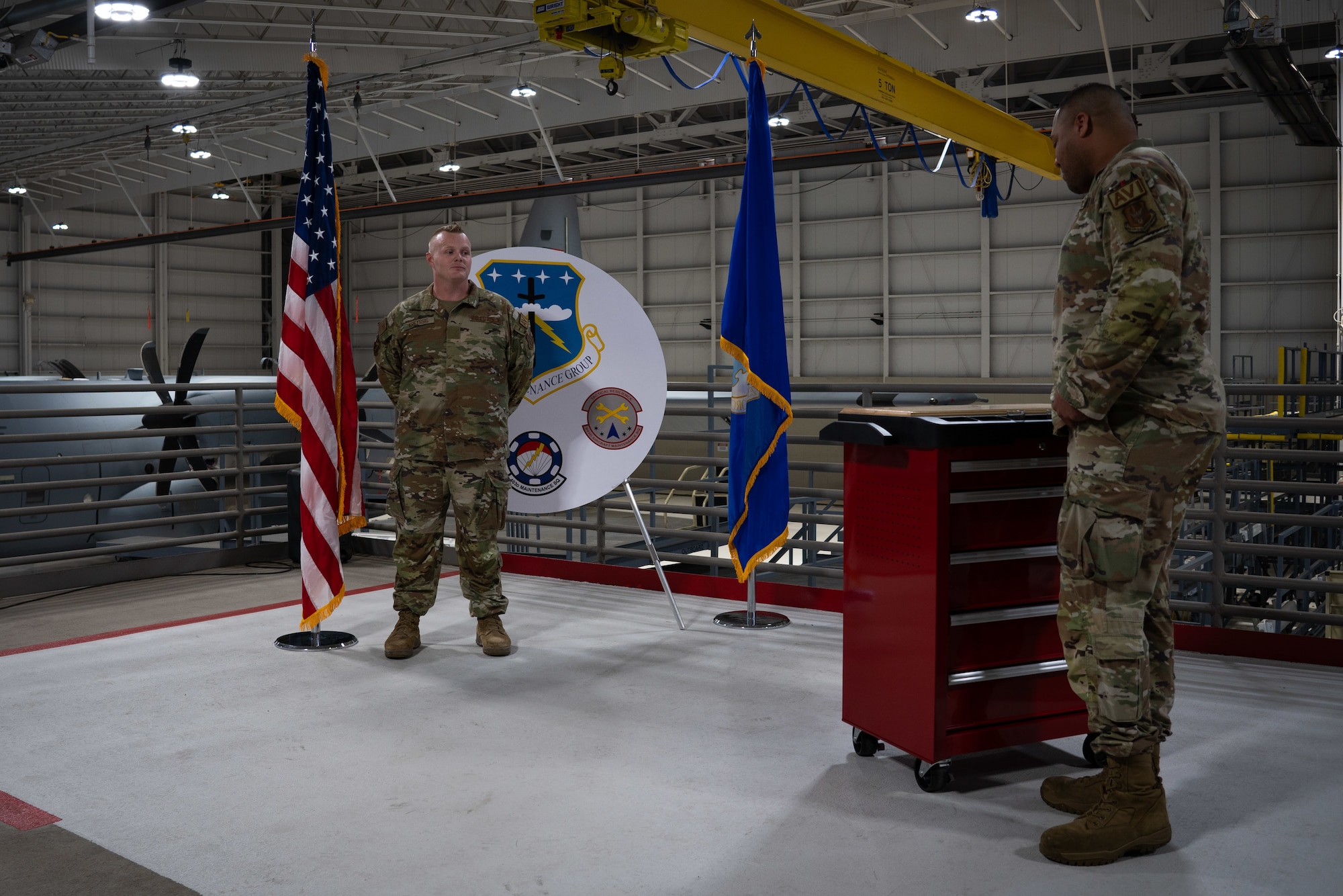 New staff sergeant stands at parade rest while be sworn into the NCO ranks by a master sergeant.