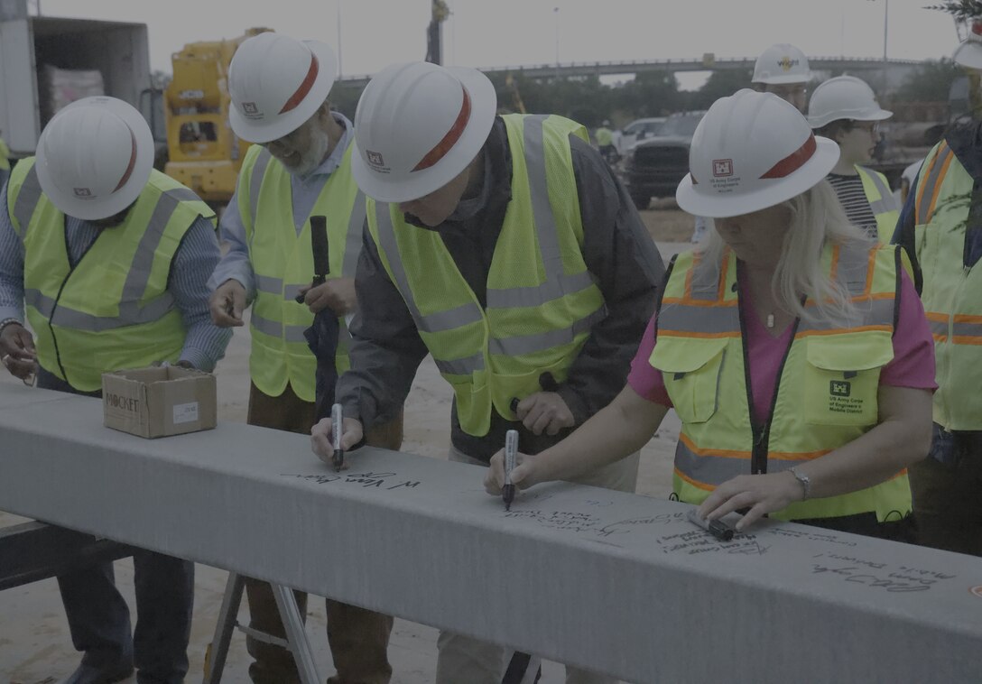 Four People signing a building beam