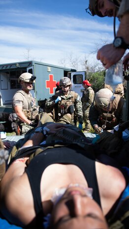 Lt. Rebecca Smith, assigned to ERCS Bravo, gets report on a simulated patient from a point of injury (POI) team consisting of special operations independent duty corpsman (SOIDC) and NEMTI staff as part of the initial course implementation of En-route Care System (ECRS) as part of the Navy's Expeditionary Medicine System (EXMED), March 16. ERCS is one of the Navy’s expeditionary medicine capabilities that provides a ready, rapidly deployable and combat effective medical forces to improve survivability across the full spectrum of care, regardless of environment. and revised provides uninterrupted care during patient movement from the point of injury (POI) through Role 4 care without clinically compromising the patients’ condition. The Navy Medicine Operational Training Command (NMOTC) is the Navy’s leader in operational medicine and trains specialty providers for aviation, surface, submarine, expeditionary, and special operations communities. (U.S. Navy photo by Mass Communication Specialist 1st Class Russell Lindsey SW/AW)