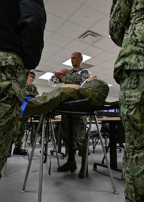 LCDR Claire Smith, assistant officer-in-charge of Naval Expeditionary Medical Training Insitute (NEMTI) demonstrates skills and techniques of the in-field patient care based on the learned experiences with the students of En-route Care System (ERCS) and Emergency Resuscitative Surgical System (ERSS) courses. ERCS is one of the Navy’s expeditionary medicine capabilities that provides a ready, rapidly deployable and combat effective medical forces to improve survivability across the full spectrum of care, regardless of environment. and revised provides uninterrupted care during patient movement from the point of injury (POI) through Role 4 care without clinically compromising the patient's condition. The Navy Medicine Operational Training Command (NMOTC) is the Navy’s leader in operational medicine and trains specialty providers for aviation, surface, submarine, expeditionary, and special operations communities. (U.S. Navy photo by Mass Communication Specialist 1st Class Russell Lindsey SW/AW)
