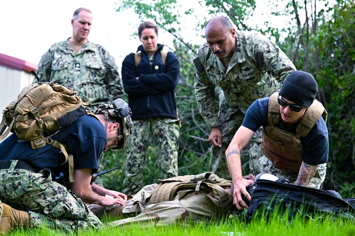 CDR Martin Boese (left) and LCDR Michelle Caskey (center), assigned to Emergency Resuscitative Surgical System (ERSS) Bravo watch as instructors demonstrate point-of-injury care and implement trauma combat casualty care (TCCC) on a simulated patient as part of an Operational Readiness Evaluation (ORE) of Navy EXMED capabilities at Naval Expeditionary Medical Training Institute (NEMTI), March 14. ERSS is one of the Navy’s expeditionary medicine capabilities that provides a ready, rapidly deployable and combat effective medical forces to improve survivability across the full spectrum of care, regardless of environment. and provides targeted lifesaving interventions to patients onboard platforms and in austere environments without clinically compromising the patients’ condition. The Navy Medicine Operational Training Command (NMOTC) is the Navy’s leader in operational medicine and trains specialty providers for aviation, surface, submarine, expeditionary, and special operations communities. (U.S. Navy photo by Mass Communication Specialist 1st Class Russell Lindsey SW/AW)