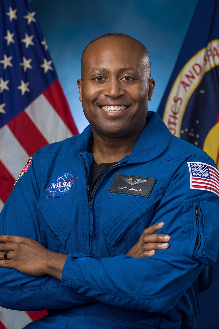 A person in a flight suit smiles for a photo.