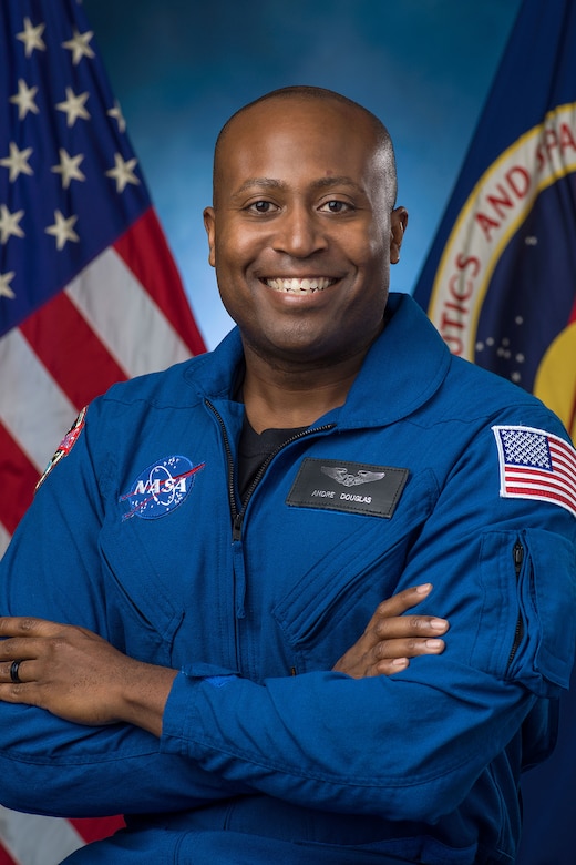 A person in a flight suit smiles for a photo.