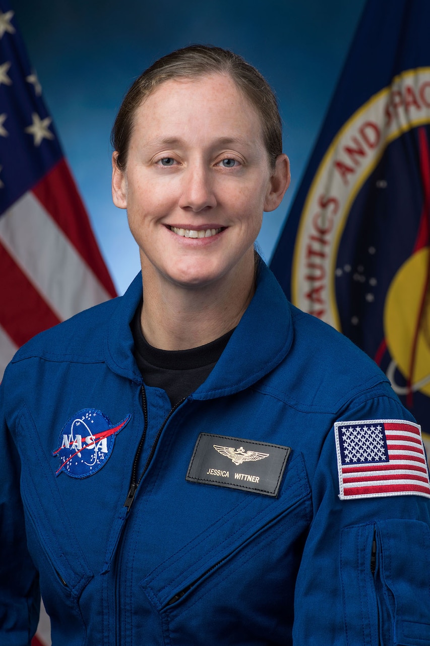 A person in a flight suit smiles for a photo.