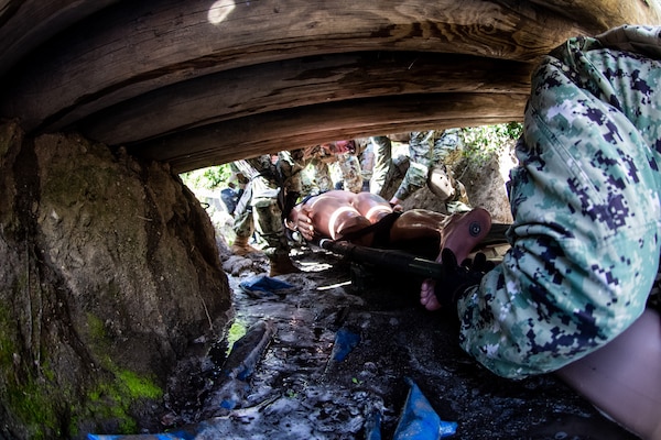 Members of ERSS and ERCS Bravo physically transport a simulated patient through an obstacle course as part of team building during the initial course implementation of En-route Care System (ERCS) and the integrated Emergency Resuscitative Surgery System (ERSS) course, March 14. ERCS is one of the Navy’s expeditionary medicine capabilities that provides a ready, rapidly deployable and combat effective medical forces to improve survivability across the full spectrum of care, regardless of environment. and revised provides uninterrupted care during patient movement from the point of injury (POI) through Role 4 care without clinically compromising the patients’ condition. The Navy Medicine Operational Training Command (NMOTC) is the Navy’s leader in operational medicine and trains specialty providers for aviation, surface, submarine, expeditionary, and special operations communities. (U.S. Navy photo by Mass Communication Specialist 1st Class Russell Lindsey SW/AW)