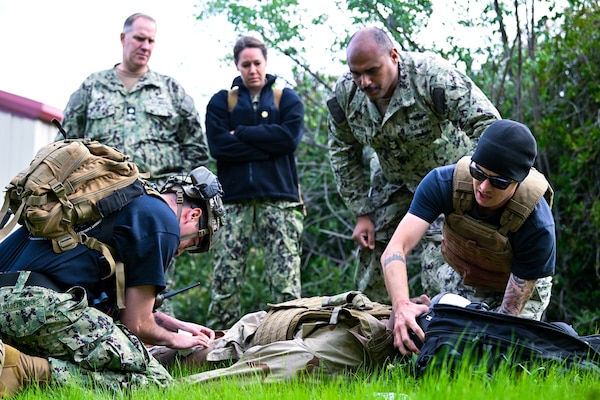 CDR Martin Boese (left) and LCDR Michelle Caskey (center), assigned to Emergency Resuscitative Surgical System (ERSS) Bravo watch as instructors demonstrate point-of-injury care and implement trauma combat casualty care (TCCC) on a simulated patient as part of an Operational Readiness Evaluation (ORE) of Navy EXMED capabilities at Naval Expeditionary Medical Training Institute (NEMTI), March 14. ERSS is one of the Navy’s expeditionary medicine capabilities that provides a ready, rapidly deployable and combat effective medical forces to improve survivability across the full spectrum of care, regardless of environment. and provides targeted lifesaving interventions to patients onboard platforms and in austere environments without clinically compromising the patients’ condition. The Navy Medicine Operational Training Command (NMOTC) is the Navy’s leader in operational medicine and trains specialty providers for aviation, surface, submarine, expeditionary, and special operations communities. (U.S. Navy photo by Mass Communication Specialist 1st Class Russell Lindsey SW/AW)