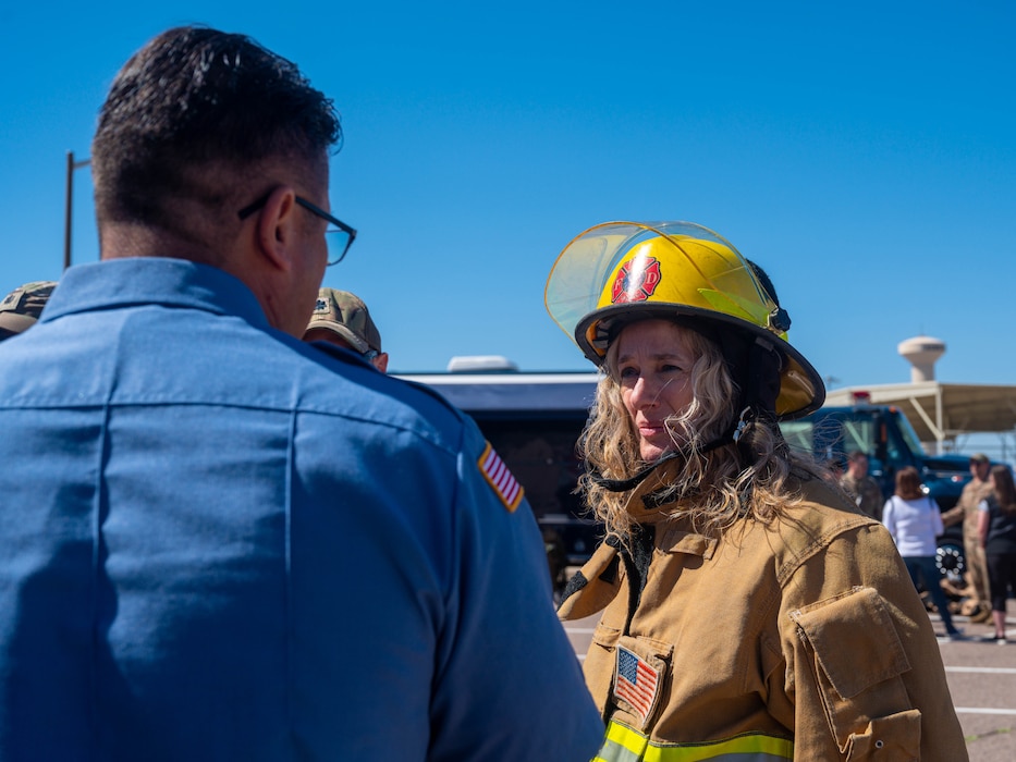 Karen Longo, 756th Aircraft Maintenance Squadron honorary commander, speaks with a member of the Luke Air Force Base Fire Department March 24, 2023, at Luke AFB, Arizona.