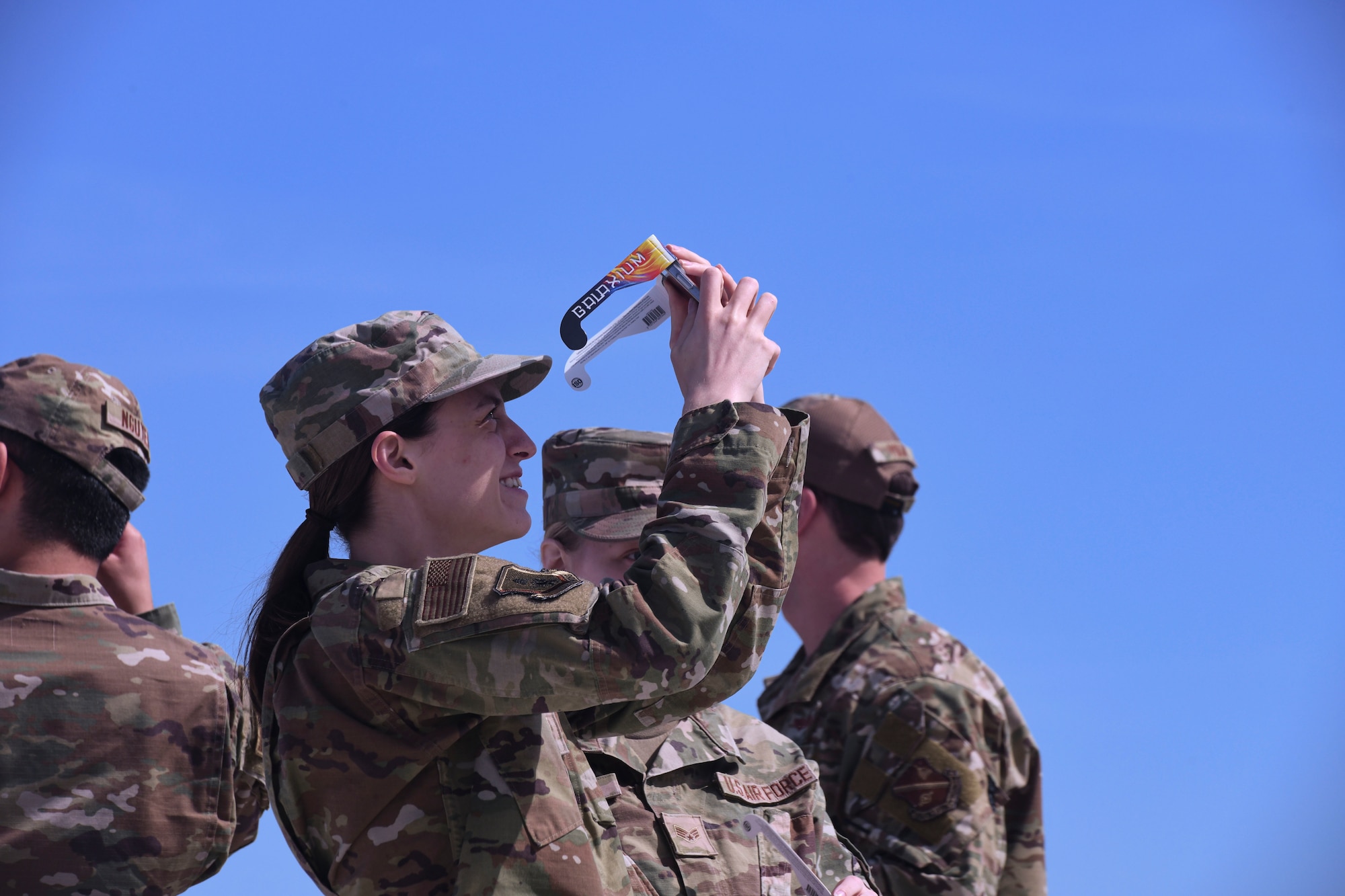Woman in uniform looks up toward sky.