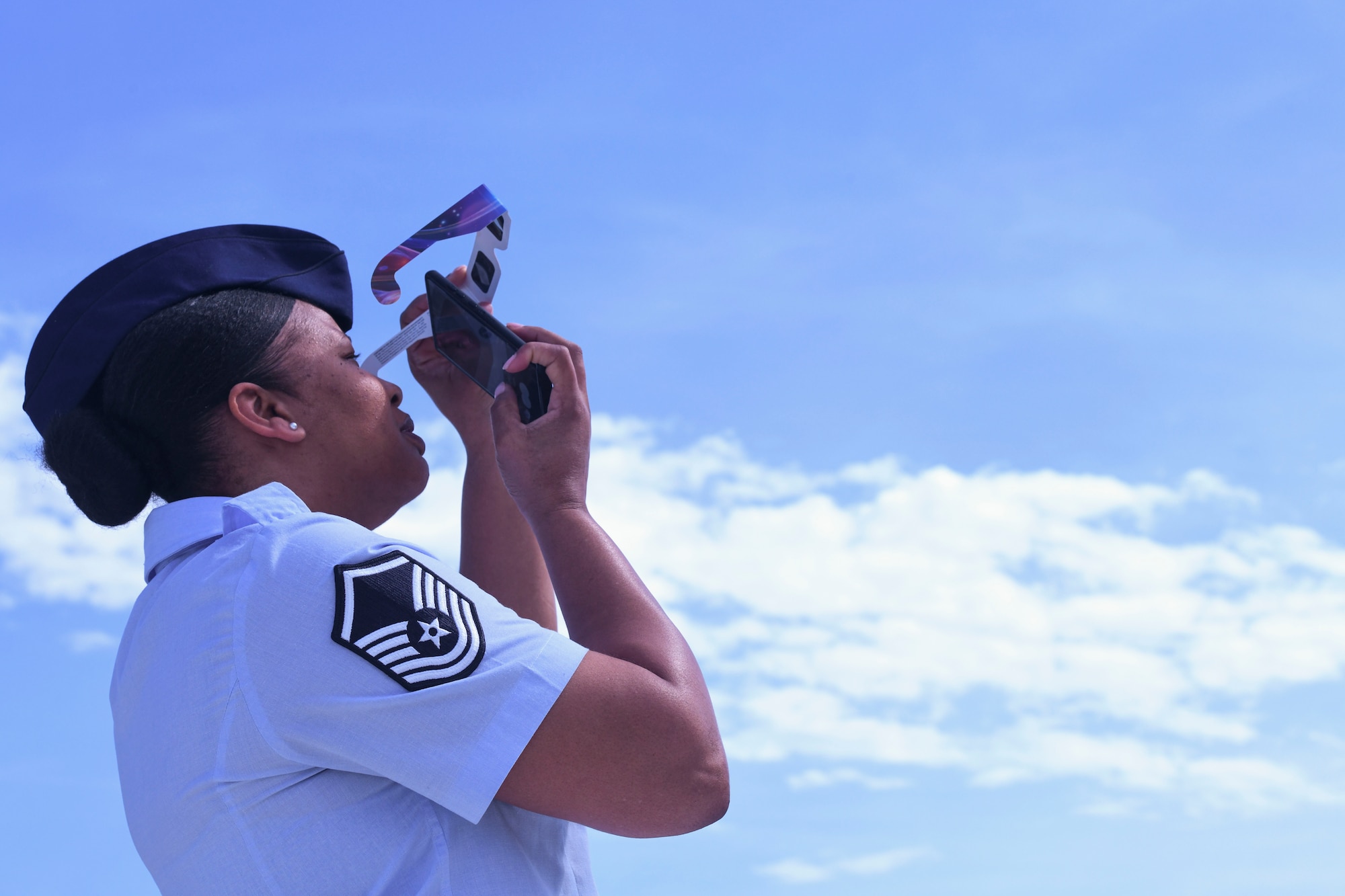 Woman in uniform looks up toward sky.