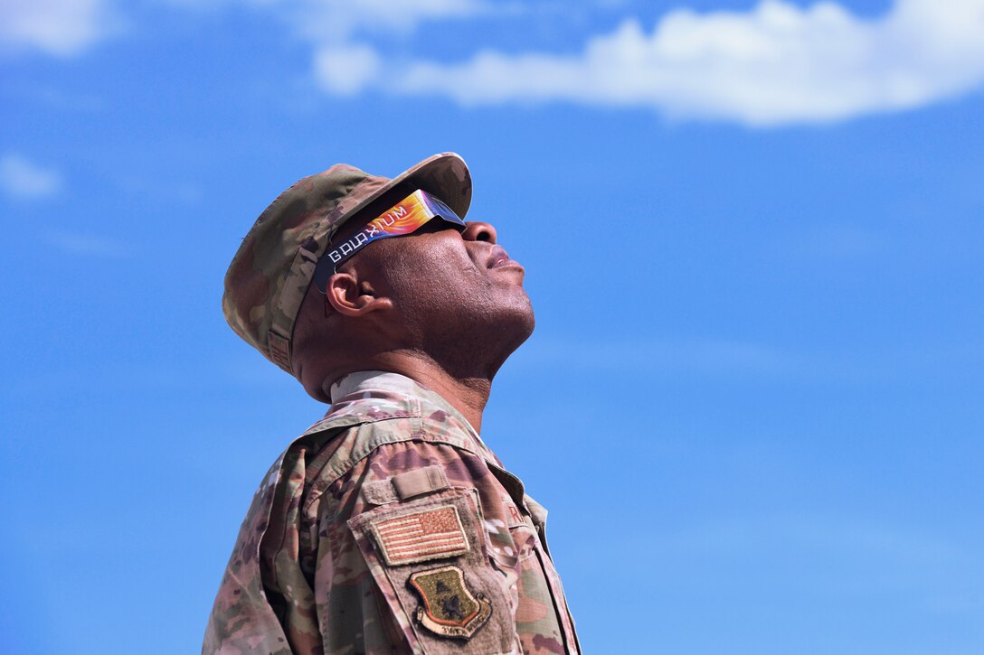 Man in uniform looks up at the sky.