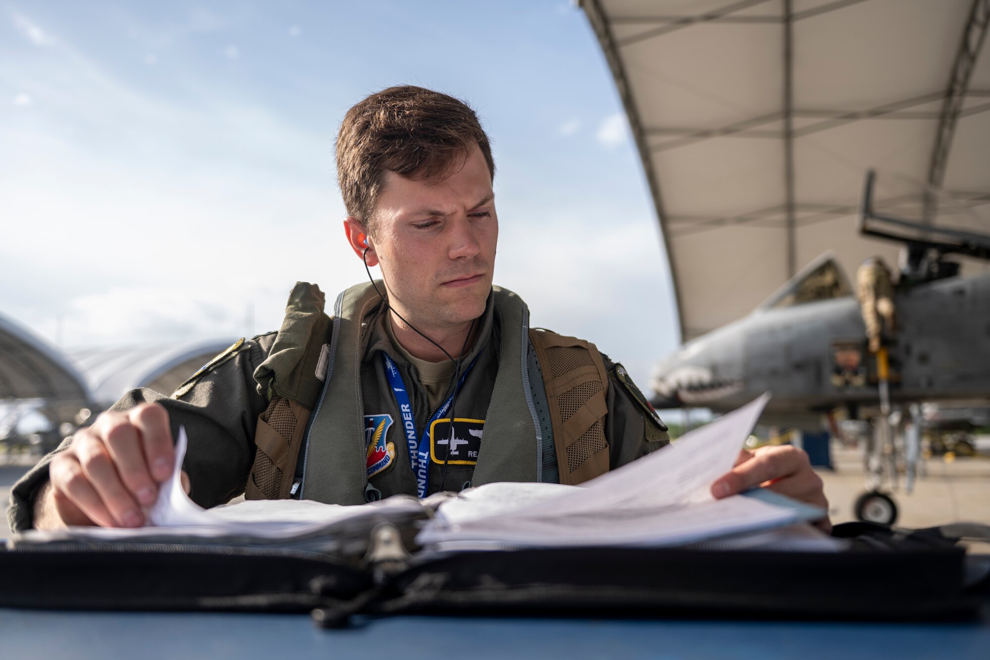 U.S. Air Force Capt. Riley Nix, 74th Fighter Squadron A-10C Thunderbolt II pilot, reviews maintenance logs during Exercise Ready Tiger 24-1 at Moody Air Force Base, Georgia, April 10, 2024. A-10s have excellent maneuverability at low air speeds and altitude and are highly accurate weapons-delivery platforms. Ready Tiger 24-1 is a readiness exercise demonstrating the 23rd Wing’s ability to plan, prepare and execute operations and maintenance to project air power in contested and dispersed locations, defending the United States’ interests and allies. (U.S. Air Force photo by Senior Airman Deanna Muir)
