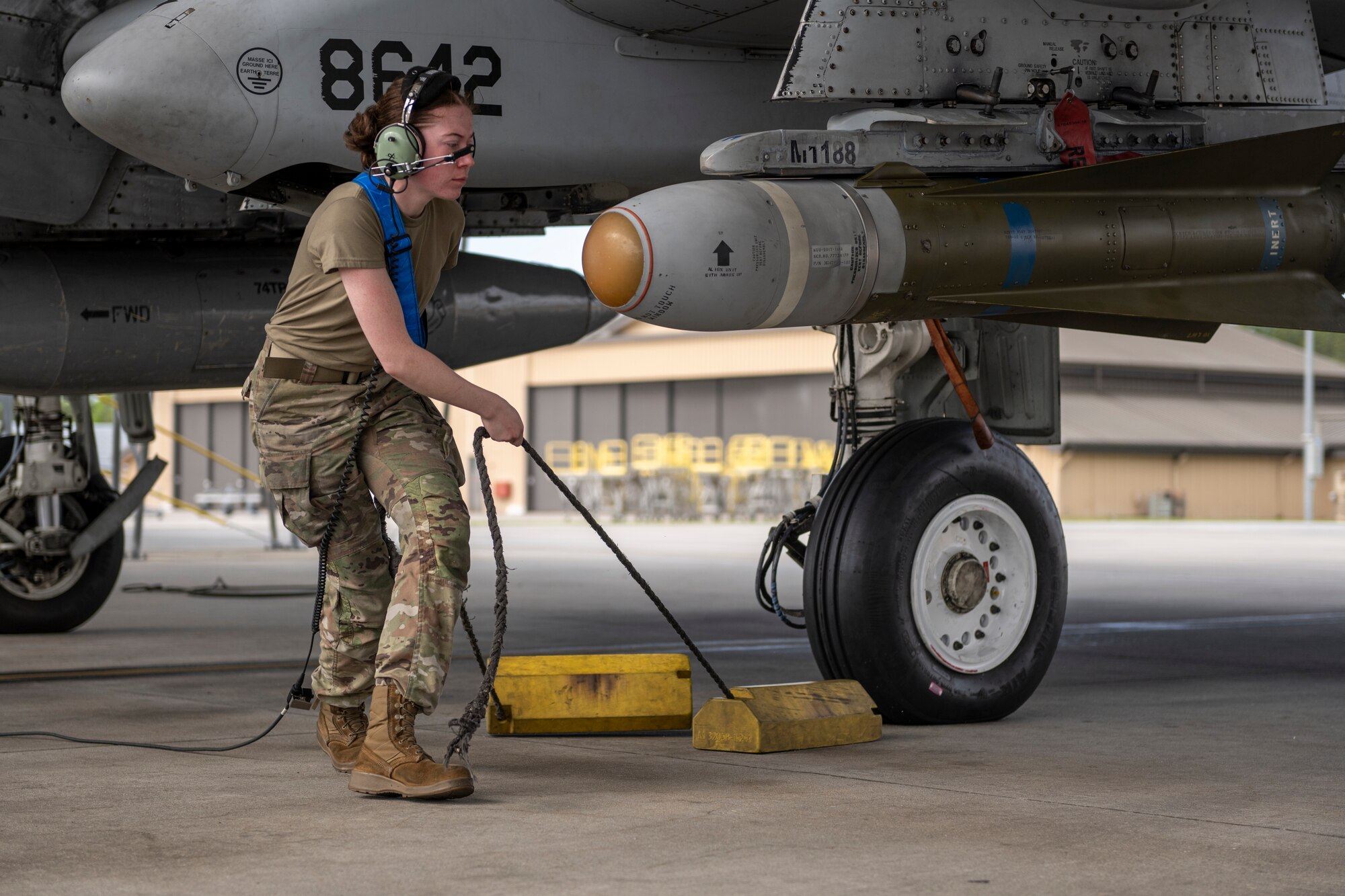 U.S. Air Force Airman Gabrielle Shipley, 74th Fighter Generation Squadron crew chief, removes chocks from an A-10C Thunderbolt II during Exercise Ready Tiger 24-1 from Moody Air Force Base, Georgia, April 10, 2024. Chocking an aircraft is an important safety precaution that helps prevent the aircraft from moving while it is parked. During Ready Tiger 24-1, the 23rd Wing will be evaluated on the integration of Air Force Force Generation principles such as Agile Combat Employment, integrated combat turns, forward aerial refueling points, multi-capable Airmen, and combat search and rescue capabilities. (U.S. Air Force photo by Senior Airman Deanna Muir)