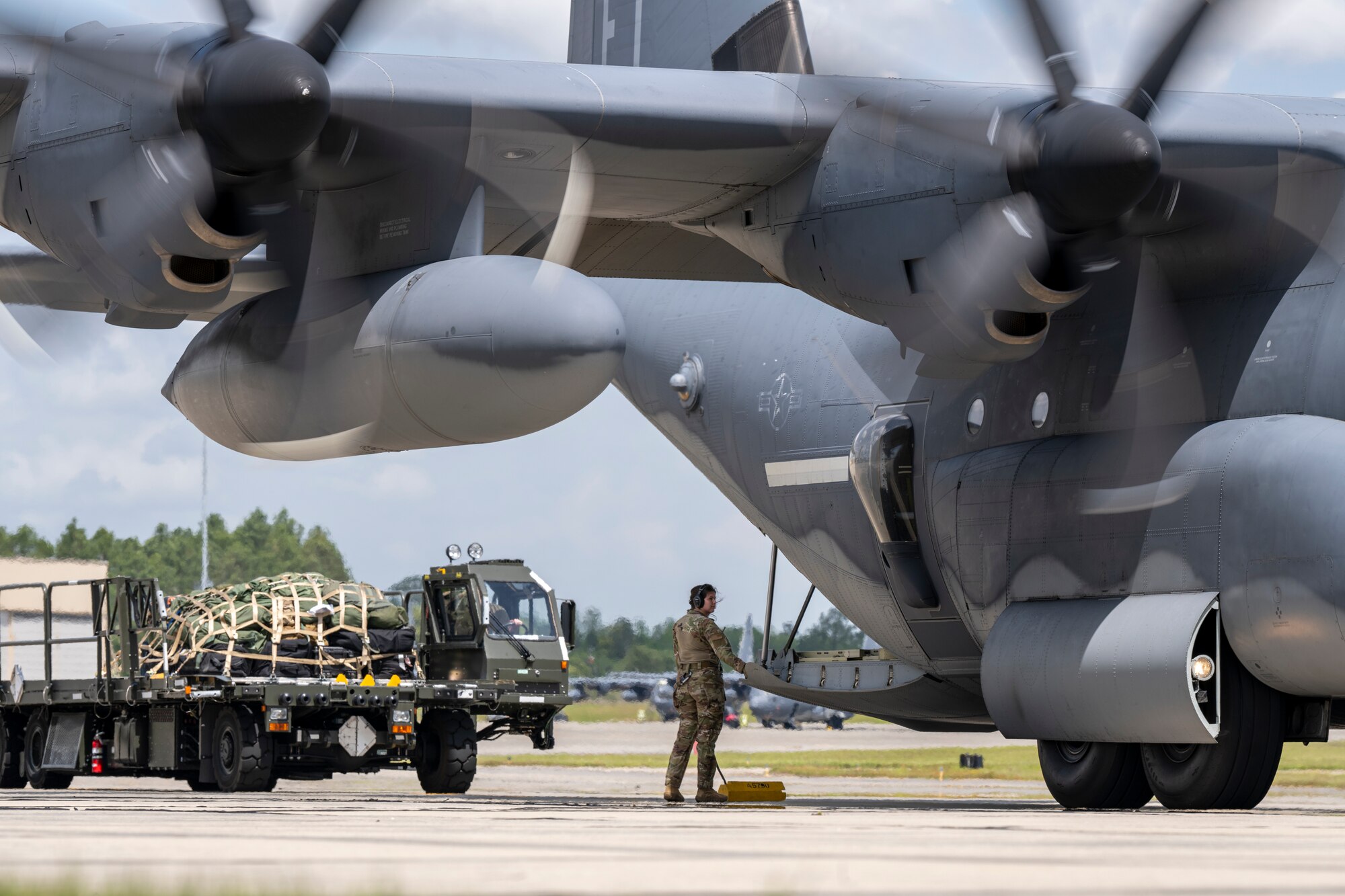A U.S. Air Force loadmaster assigned to the 71st Rescue Squadron prepares to load cargo onto an HC-130J Combat King II during Exercise Ready Tiger 24-1 from Moody Air Force Base, Georgia, April 10, 2024. A loadmaster's duties include mathematically preplanning the correct placement of the load on the airplane, providing passenger comfort and safety, securing cargo and taking part in airdrop operations. Ready Tiger 24-1 is a readiness exercise demonstrating the 23rd Wing’s ability to plan, prepare and execute operations and maintenance to project air power in contested and dispersed locations, defending the United States’ interests and allies. (U.S. Air Force photo by Senior Airman Deanna Muir)
