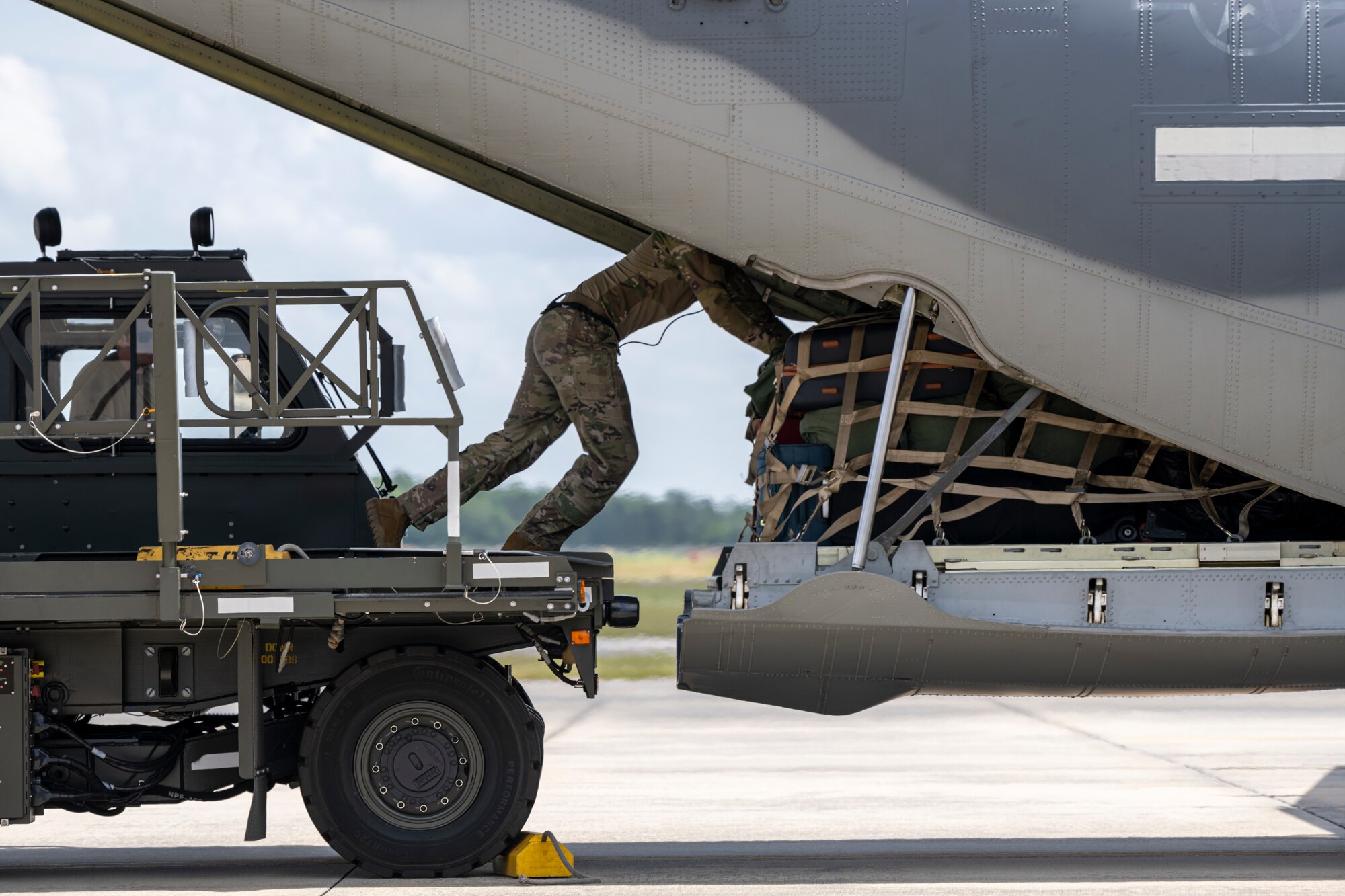 A U.S. Air Force loadmaster assigned to the 71st Rescue Squadron prepares to load cargo onto an HC-130J Combat King II during Exercise Ready Tiger 24-1 from Moody Air Force Base, Georgia, April 10, 2024. A loadmaster's duties include mathematically preplanning the correct placement of the load on the airplane, providing passenger comfort and safety, securing cargo and taking part in airdrop operations. Ready Tiger 24-1 is a readiness exercise demonstrating the 23rd Wing’s ability to plan, prepare and execute operations and maintenance to project air power in contested and dispersed locations, defending the United States’ interests and allies. (U.S. Air Force photo by Senior Airman Deanna Muir)