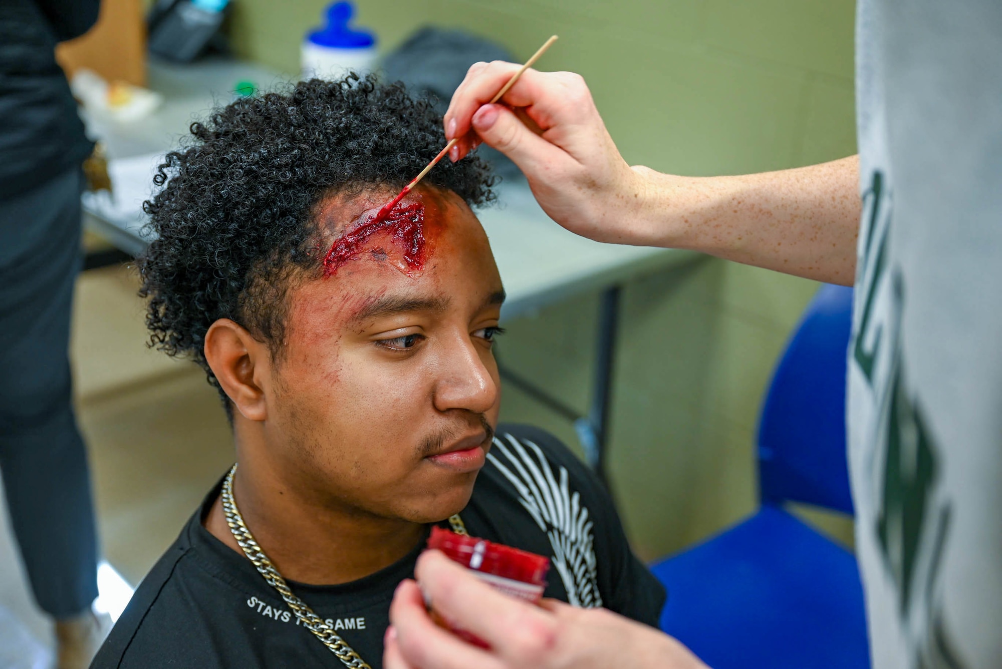 A student from the 81st Training Group receives an artificial wound from a moulage artist at a disaster exercise at Gulfport-Biloxi International Airport, Gulfport, Mississippi, March 28, 2024.