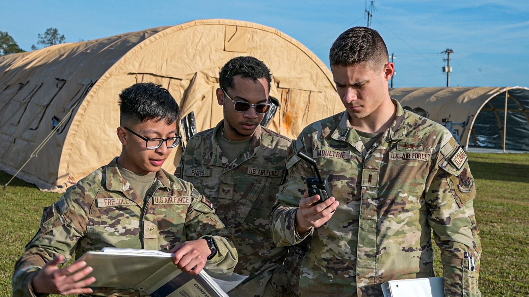 U.S. Air Force Airman Randy Frejoles, left, 23rd Communications Squadron radio frequency operator, Senior Airman Devante Phipps, middle, 23rd CS radio supervisor, and 2nd Lt. Jake Moultrie, 23rd CS radio officer in charge, test connectivity at Avon Park Air Force Range, Florida, April 9, 2024. The ability to establish communications is crucial to successfully establishing a forward operating site in a contingency location. The Ready Tiger 24-1 exercise evaluators will assess the 23rd Wing's proficiency in employing decentralized command and control to fulfill air tasking orders across geographically dispersed areas amid communication challenges. (U.S. Air Force photo by Airman 1st Class Leonid Soubbotine)