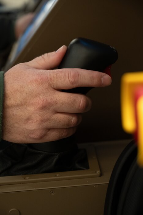 A hand operates the control stick for the KC-46 boom operations simulator.