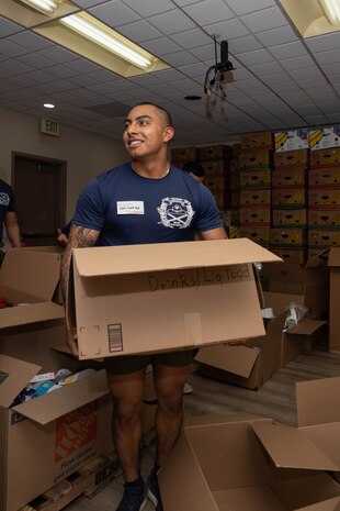 U.S. Marine Corps Sgt. Rafael Garcia, a drill instructor with India Company, 3rd Recruit Training Battalion, moves a box of donations during a volunteer event at a Ronald McDonald House in San Diego, California, April 8, 2024. The Ronald McDonald House provides a home away from home at no cost for families with sick and injured children, ages 21 and younger. (U.S. Marine Corps photo by Lance Cpl. Janell B. Alvarez)