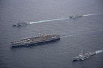 Ships assigned to the Theodore Roosevelt Carrier Strike Group, Japan Maritime Self-Defense Force and Republic of Korea Navy with aircraft assigned to Carrier Air Wing (CVW) 11 sail in formation during a trilateral exercise, April 11, 2024. This trilateral exercise allowed maritime forces from Japan, the Republic of Korea, and U.S. to train together to enhance coordination on maritime domain awareness and other shared security interests. The Theodore Roosevelt Carrier Strike Group is deployed to the U.S. 7th Fleet area of operations in support of a free and open Indo-Pacific.(U.S. Navy photo by Mass Communication Specialist 1st Class Tommy Gooley)