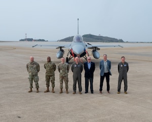 Personnel standing in front of an F-16.
