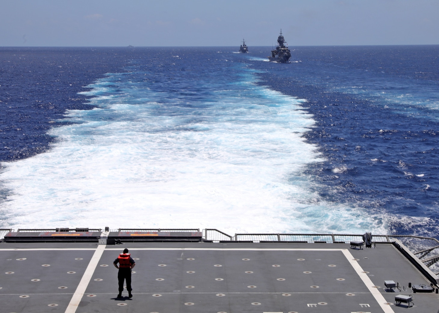 Information Systems Technicians 3rd Class Isabella Tafoya, attached to the Independence-variant littoral combat ship USS Mobile (LCS 26), observes the Royal Australian Navy frigate HMAS Warramunga (FFG152) and French Navy Floréal-class frigate FS Vendémiaire (F 734) from the flight deck, during trilateral operations in the South China Sea. Mobile, part of Destroyer Squadron 7, is on a rotational deployment operating in the U.S. 7th Fleet area of operations to enhance interoperability with Allies and partners and serve as a ready-response force in support of a free and open Indo-Pacific region. (U.S. Navy photo by Mass Communication Specialist 1st Class Liz Dunagan/RELEASED)