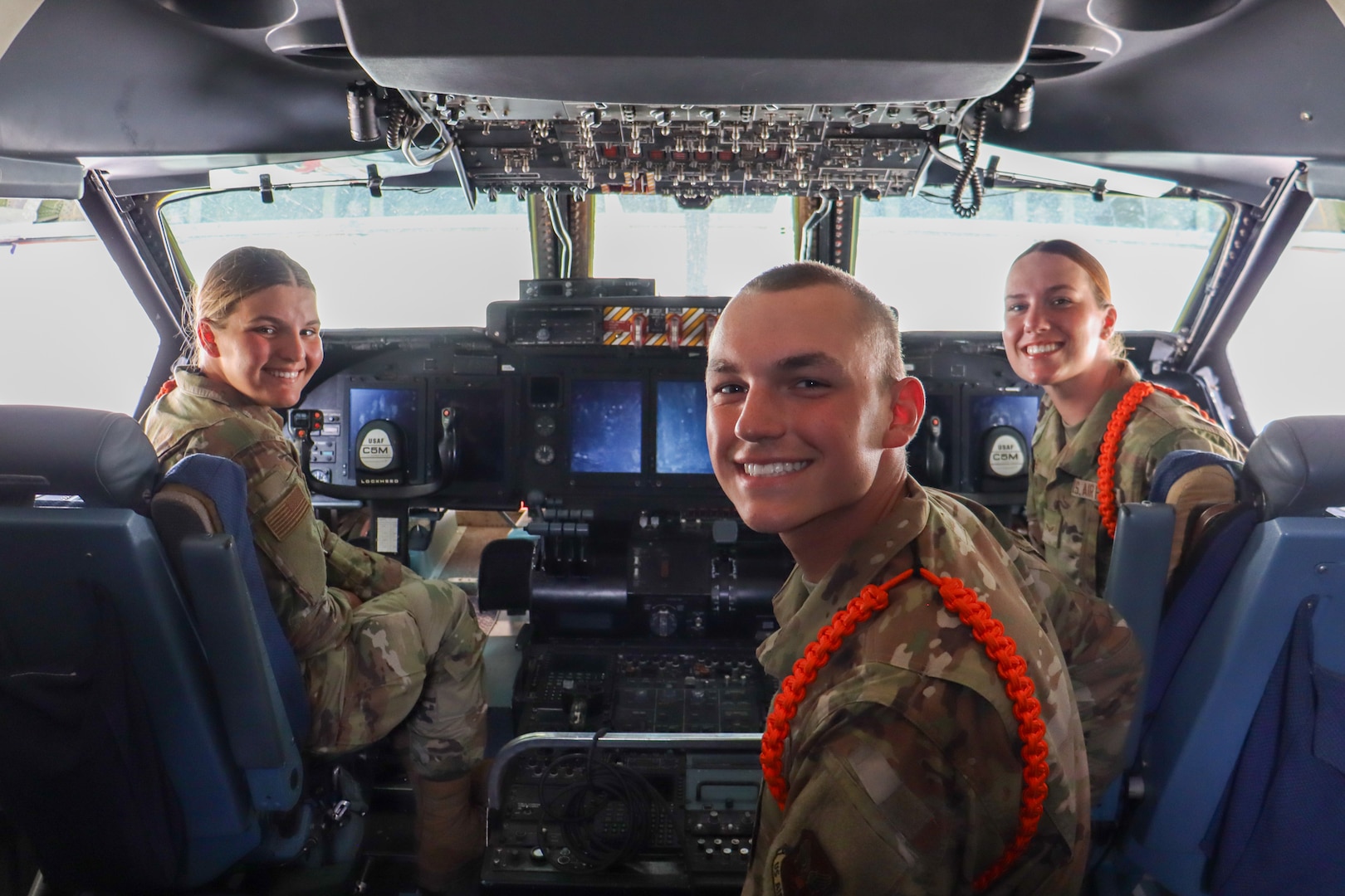 Airman Sam Murfin, left, recent Basic Military Training graduate, Airman Dane Larson, center, recent BMT graduate, and Airman 1st Class DonnaMae Smith, right, recent BMT graduate pose for photo inside the cockpit of a 433rd Airlift Wing’s C-5M Super Galaxy at The Great Texas Airshow at Joint Base San Antonio-Randolph, Texas Apr. 7, 2024.