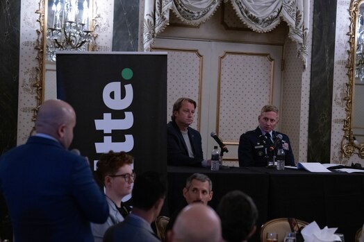  An audience member asks a question to panelists during the Outer Space to Cyber Space luncheon panel.