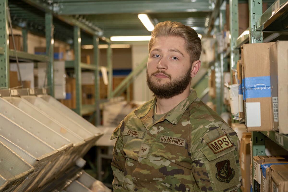 U.S. Air Force Senior Airman Travis Spong, 35th Force Support Squadron registered mail clerk, poses in front of rows of mail at Misawa Air Base, Japan, March 28, 2024.