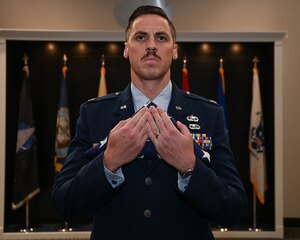 U.S. Air Force Capt. Tyler Sumrall, 17th Training Wing Chief of Commander’s Action Group, holds the Olde Glory Flag Ceremony flag during Col. Andres Nazario’s retirement ceremony at the Powell Event Center, Goodfellow Air Force Base, Texas, April 2, 2024. After 35 years of service, Nazario concluded his career as a U.S. Embassy and Consulate executive in the Mexico Defense Attache Office. (U.S. Air Force photo by Airman 1st Class Evelyn D’Errico)