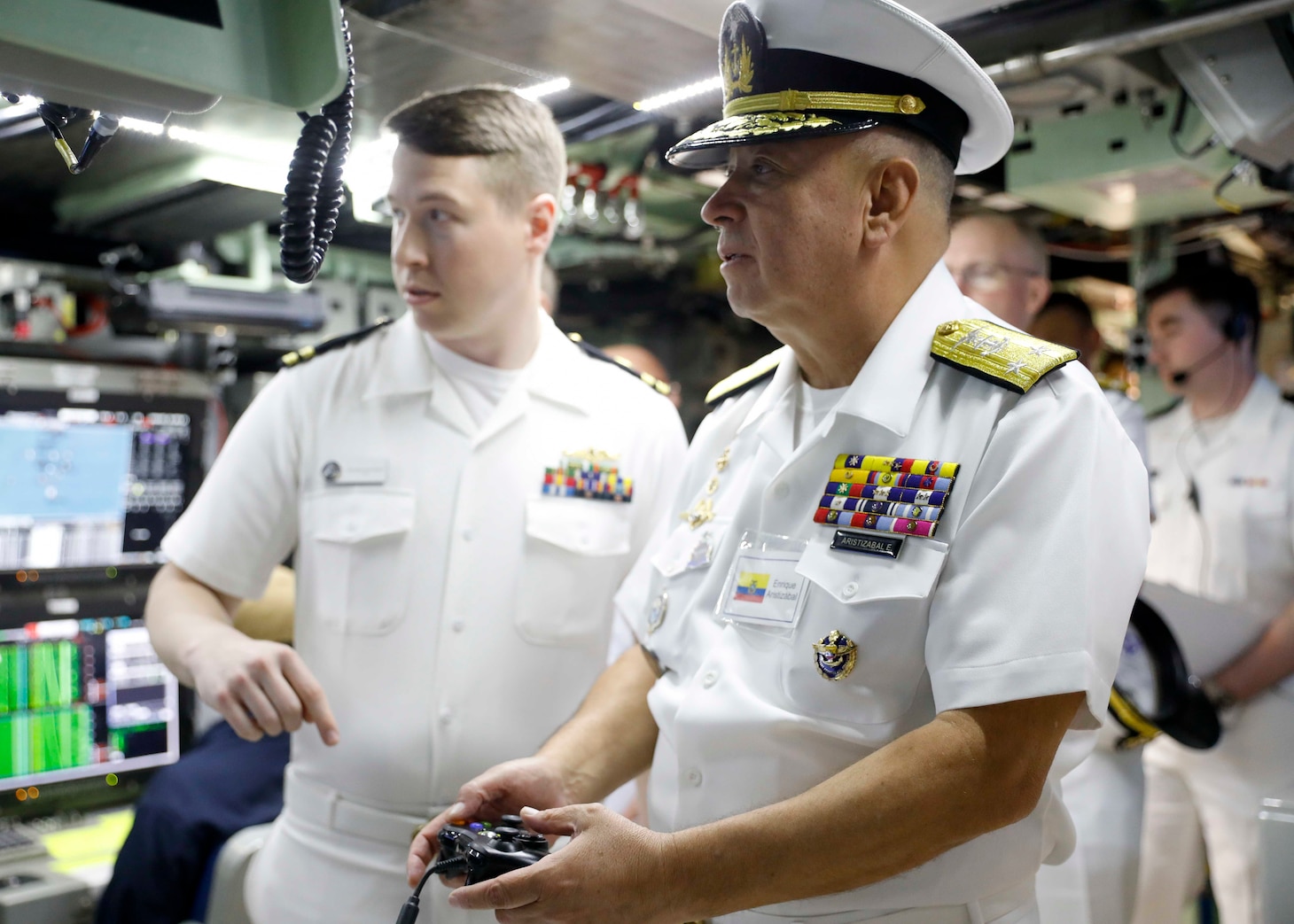 Rear Adm. Enrique Aristizábal, commander of naval operations, Ecuadorian navy, uses a controller device to operate a periscope in the control room during a tour aboard the Virginia-class fast-attack submarine USS Delaware (SSN 791) during the third annual Submarine Conference of the Americas (SCOTA) at Fort Lauderdale, Florida, April 3, 2024.