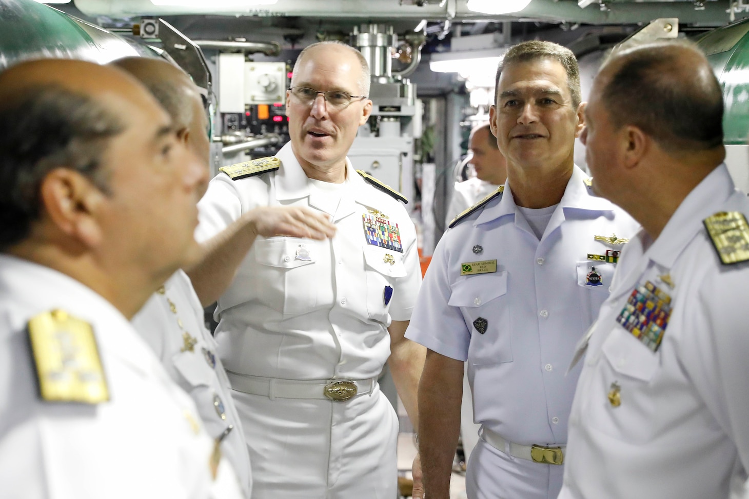 Vice Adm. Rob Gaucher, middle left, commander, Submarine Forces, speaks with allied and partner nation submarine force commanders in the torpedo room during a tour aboard the Virginia-class fast-attack submarine USS Delaware (SSN-791) during the third annual Submarine Conference of the Americas (SCOTA) at Fort Lauderdale, Florida, April 3, 2024.