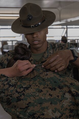 A U.S. Marine Corps drill instructor with Charlie Company, 1st Recruit Training Battalion inspects a recruit’s uniforms during the series commander inspection at Marine Corps Recruit Depot San Diego, California, April 5, 2024. The series commander inspection is one of several inspections recruits will undergo throughout the duration of their training at MCRD San Diego and aims to ensure the recruits are upholding the uniform orders given to them. (U.S. Marine Corps photo by Lance Cpl. Alexandra M. Earl)