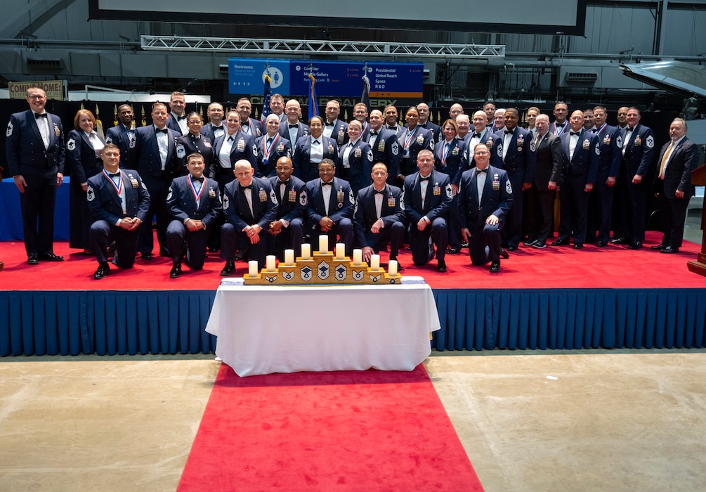 The chief master sergeants, active and retired, of Wright-Patterson Air Force Base, Ohio, gather on stage April 5, 2024, at the end of the chief recognition ceremony in the National Museum of the U.S. Air Force. The annual event honored 11 Wright-Patt Airmen selected for promotion to the Air Force’s highest enlisted rank. (U.S. Air Force photo by R.J. Oriez)