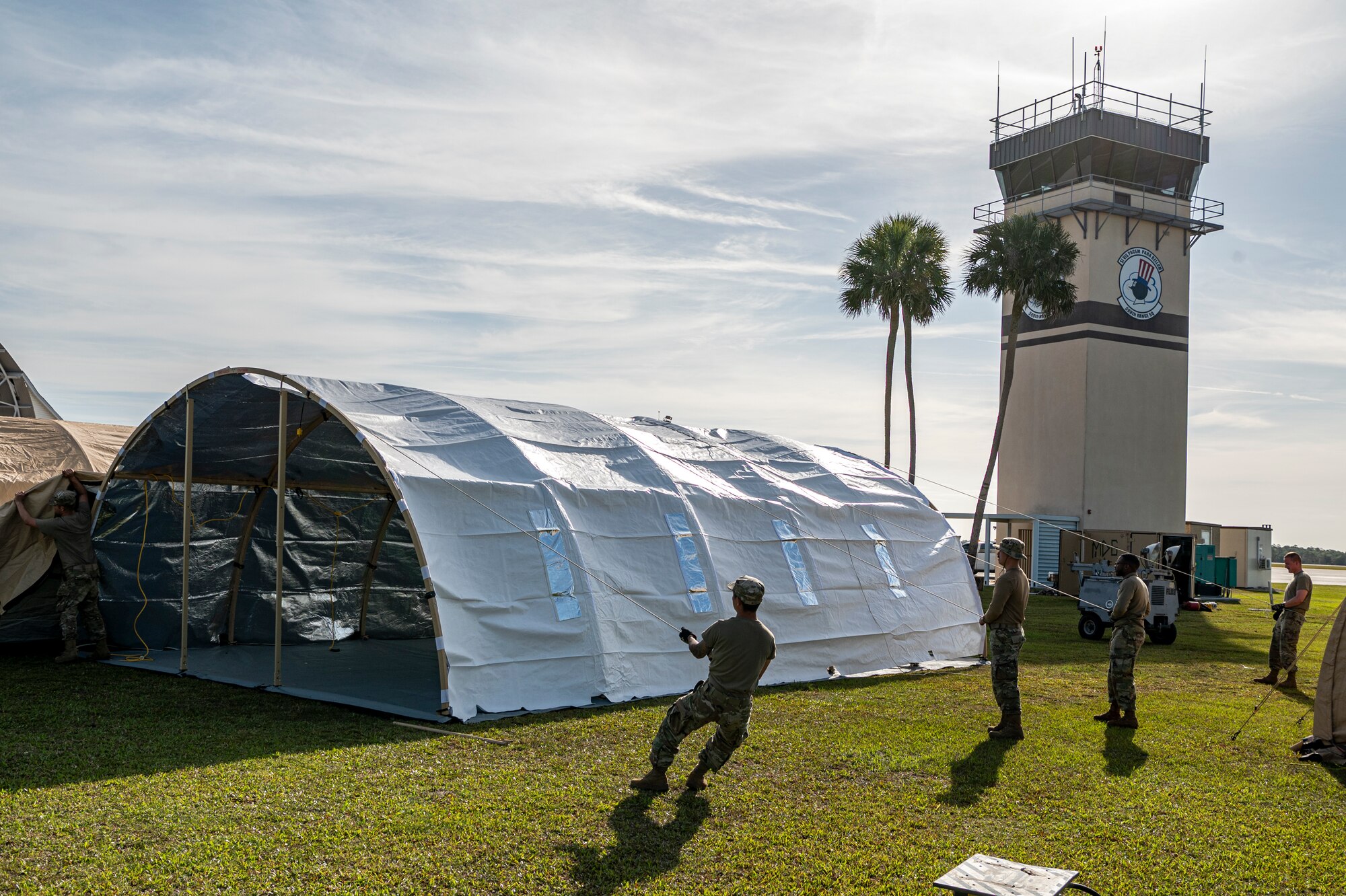 U.S. Air Force Airmen assigned to the 23rd Logistics Readiness Squadron pull a canopy over a tent frame at Avon Park Air Force Range, Florida, April 9, 2024. Due to the unpredictable nature in austere environments, establishing shelters for operations ensures Airmen can operate in a secure location, generating combat airpower anywhere and anytime.  (U.S. Air Force photo by Airman 1st Class Leonid Soubbotine)