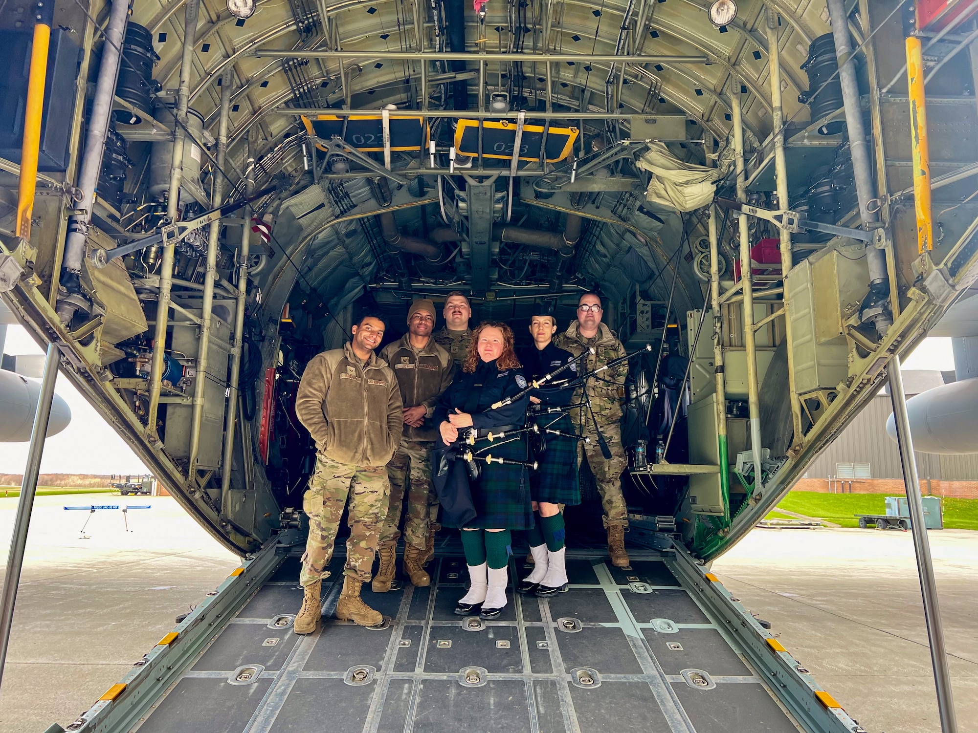 Members of the Steel Valley Pipes and Drums and 910th Airlift Wing Airmen, pose for a photo in front of a C-130H Hercules during the 910th AW Career and Diversity Day, April 6, 2024, at Youngstown Air Reserve Station, Ohio.
