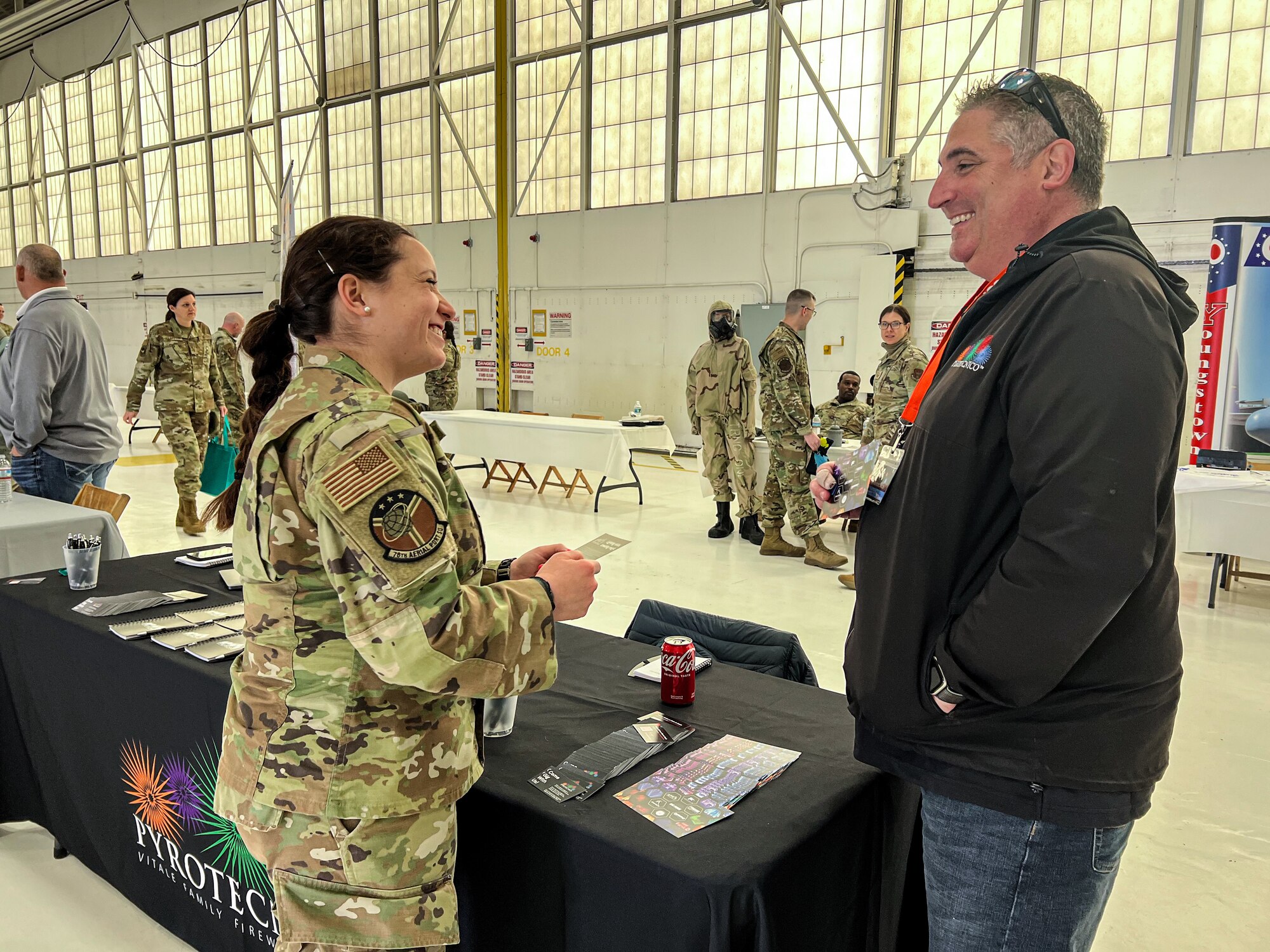 Master Sgt. Melanie Mendoza, an air terminal operation center representative assigned to the 910th Aerial Port Squadron, and Damian DiCola, owner of Pyrotecnico, discuss current job opportunities for Airmen during the 910th AW Career and Diversity Day, April 6, 2024, at Youngstown Air Reserve Station, Ohio.