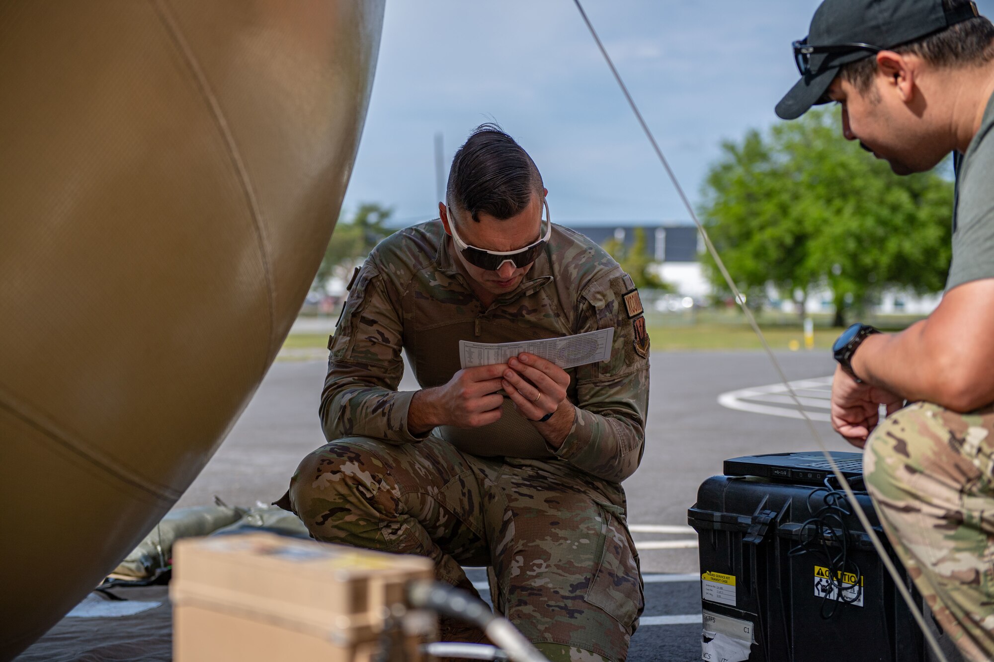 U.S. Air Force Tech. Sgt. Leif Anderson, 52nd Combat Communications Squadron tactical communications supervisor, reads a satellite slide rule next to a Global Air Terminal Radio during Exercise Ready Tiger 24-1 at Savannah Air National Guard Base, Georgia, April 9, 2024. Equipment such as the GATR establishes secure communication for command and control in distributed operations. The Ready Tiger 24-1 exercise evaluators will assess the 23rd Wing's proficiency in employing decentralized command and control to fulfill air tasking orders across geographically dispersed areas amid communication challenges. (U.S. Air Force photo by Senior Airman Courtney Sebastianelli)