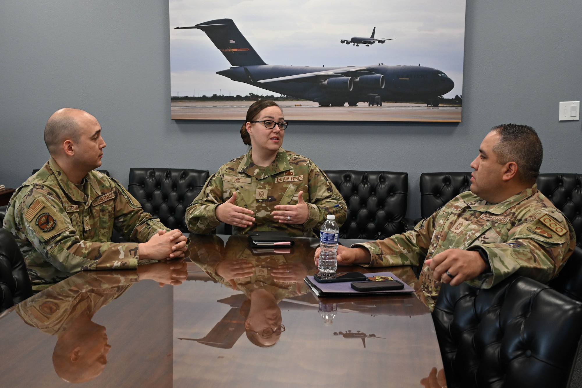 U.S. Air Force Master Sgt. Jesica Ruz (center), 97th Logistics Readiness Squadron superintendent of plans and integration, speaks to Master Sgt. Joshua Butterbaugh (left), 97th Contracting Flight (CONF) senior enlisted leader, and Chief Master Sgt. Christopher Trevino (right), Air Force Installation Contracting Agency (AFICC/KT) chief enlisted manager, at Altus Air Force Base, Oklahoma, April 3, 2024. Airmen and leadership from the 97th Mission Support Group and 97th CONF met with AFICC/KT leadership to familiarize them with the 97th CONF mission. (U.S. Air Force photo by Senior Airman Miyah Gray)