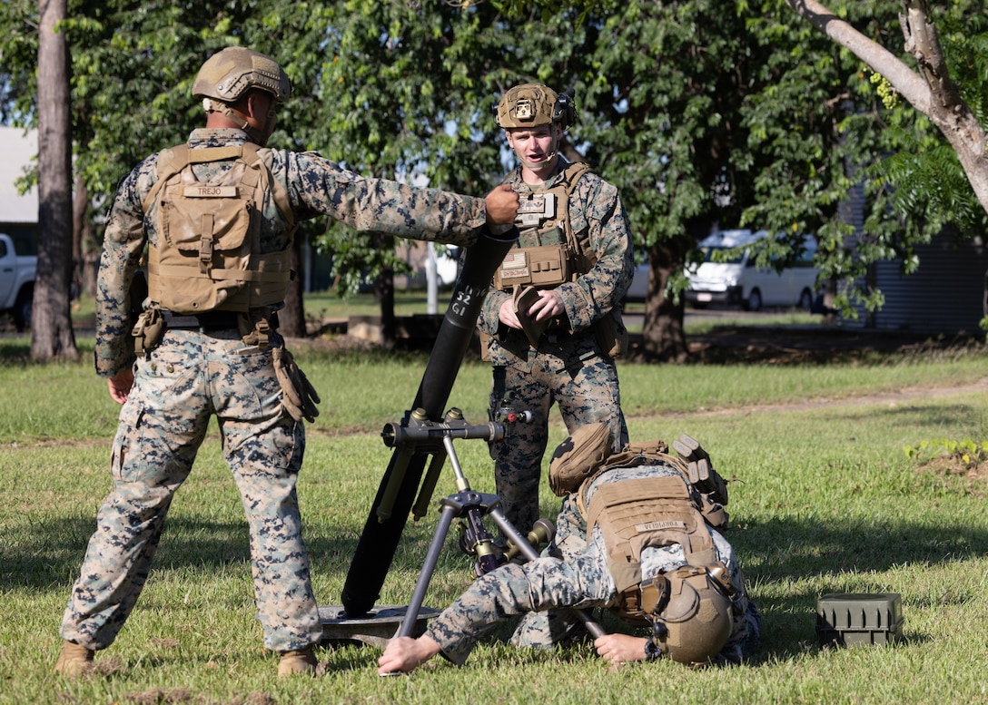 U.S. Marine Corps Cpl. Marco Trejo, left, a mortarman, Cpl. Kaleb Waggoner, center, a squad leader and Cpl. Dominic Porpiglia, a team leader, all with Weapons Company, 2nd Battalion, 5th Marine Regiment (Reinforced), Marine Rotational Force – Darwin 24.3, rehearse M252 81 mm mortar system gun drills at Robertson Barracks, Darwin, NT, Australia, April 8, 2024. MRF-D 24.3 is part of an annual six-month rotational deployment to enhance interoperability with the Australian Defense Force and Allies and partners and provide a forward-postured crisis response force in the Indo-Pacific. Trejo is a native of Texas. Waggoner is a native of Ohio. Porpiglia is a native of Florida. (U.S. Marine Corps photo by Cpl. Earik Barton)