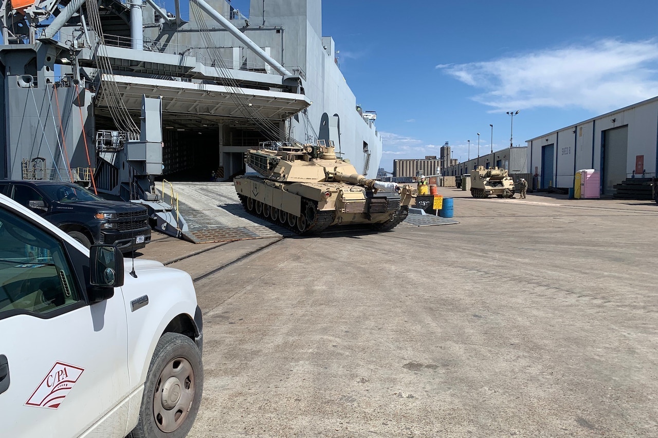 A tank rolls off a ship.