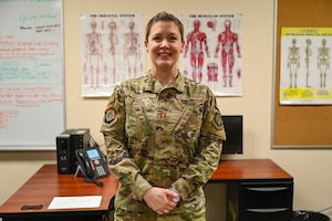 An Airman Stands in front of desk