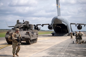 Airmen with the 621st Air Mobility Advisory Group assigned to and soliders with the 5th Squadron, 7th Cavalry Regiment escort a M2A3 Bradley Fighting Vehicle during Exercise SWAMP AVENGER 24-2 at North Auxillary Field, South Carolina, April 2, 2024.