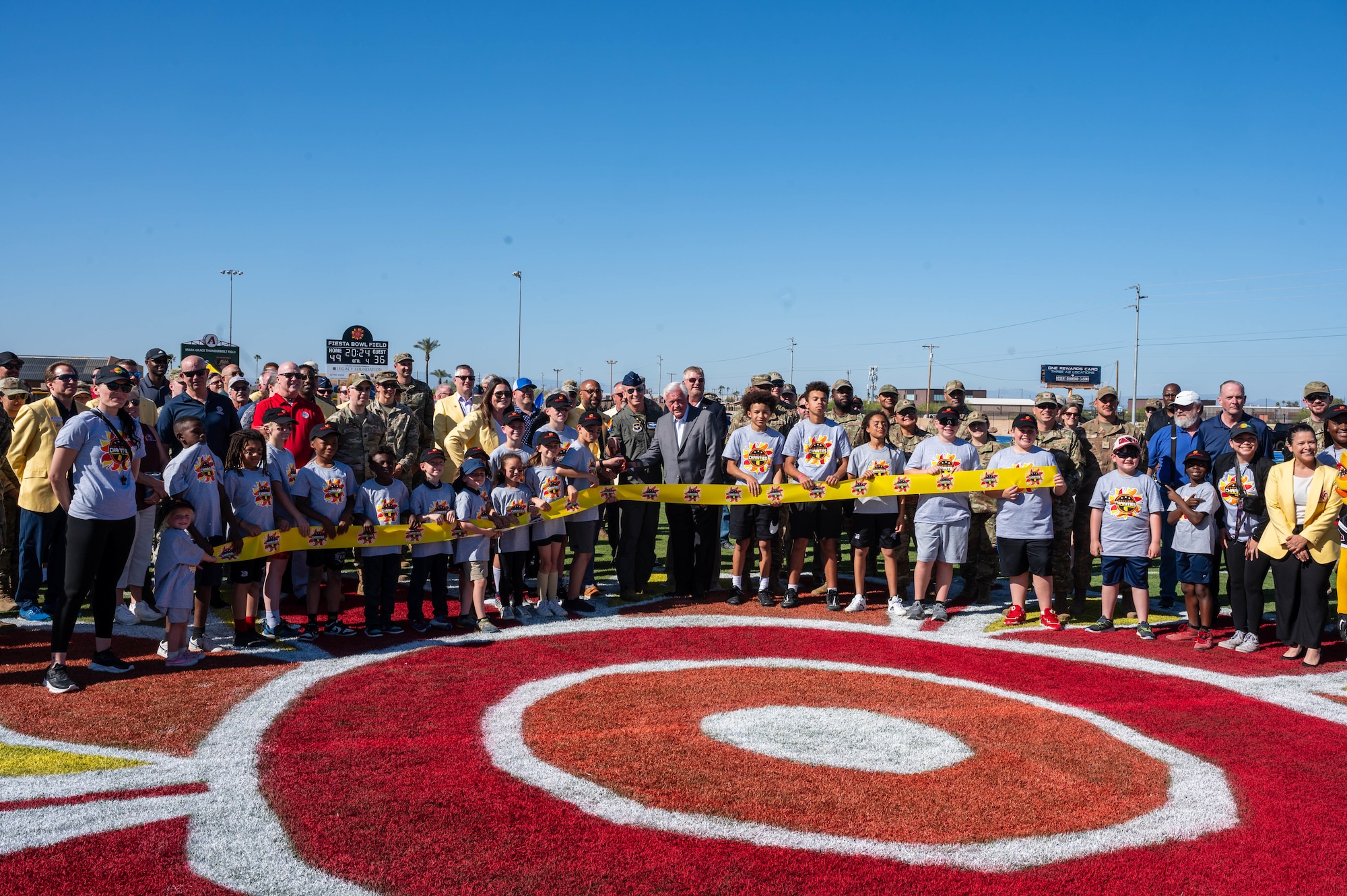 Leadership and other community members of the 56th Fighter Wing cut a ribbon during a reopening ceremony of the Fiesta Bowl field, April 11, 2024, at Luke Air Force Base, Arizona.