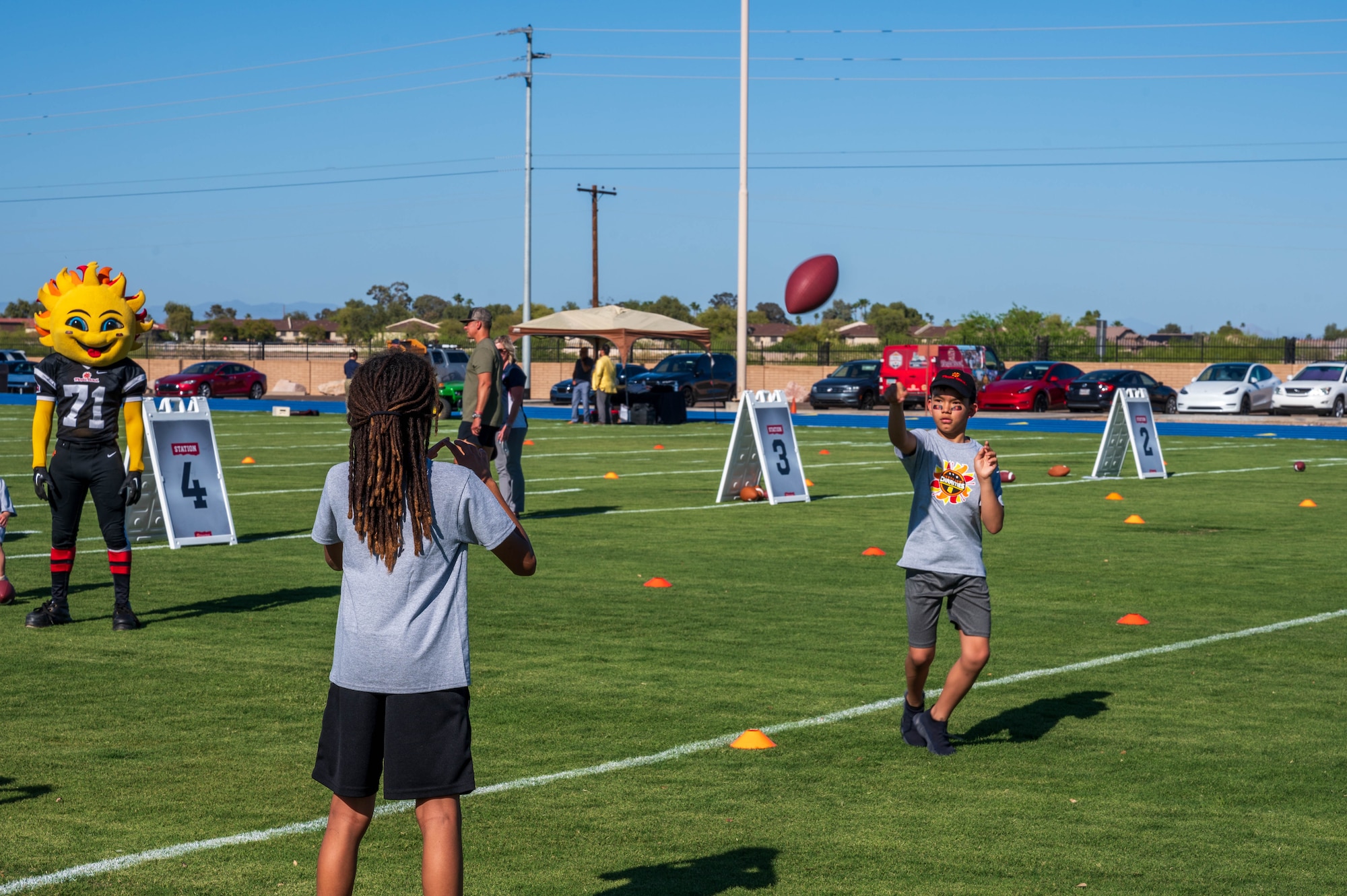 Luke Air Force Base children participate in a football training camp during the opening of the Fiesta Bowl field, April 11, 2024, at Luke Air Force Base, Arizona.
